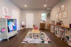 Home remodel example with children's playroom. Side wall storage with seating and a small table in the middle