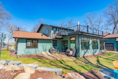 Rear view of a home remodel in Fitchburg Wisconsin. Home has a sunroom with upper patio deck