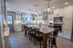 modern kitchen remodeled with white granite counters and cabinets, new steel appliances and lighting fixtures.